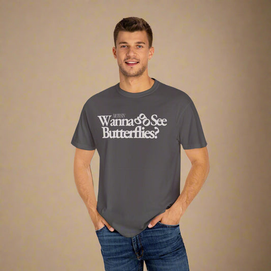 Man wearing a gray t-shirt with wanna go see butterflies text on a white background