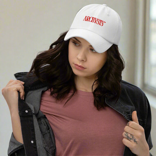 Woman wearing a white cap with 'ARCHIVIST' logo on a gray background