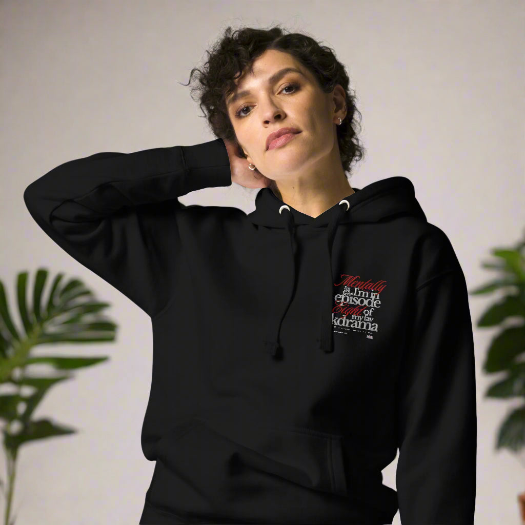 Person wearing a black hoodie with text design mentally I am on episode 8 hoodie on a white background