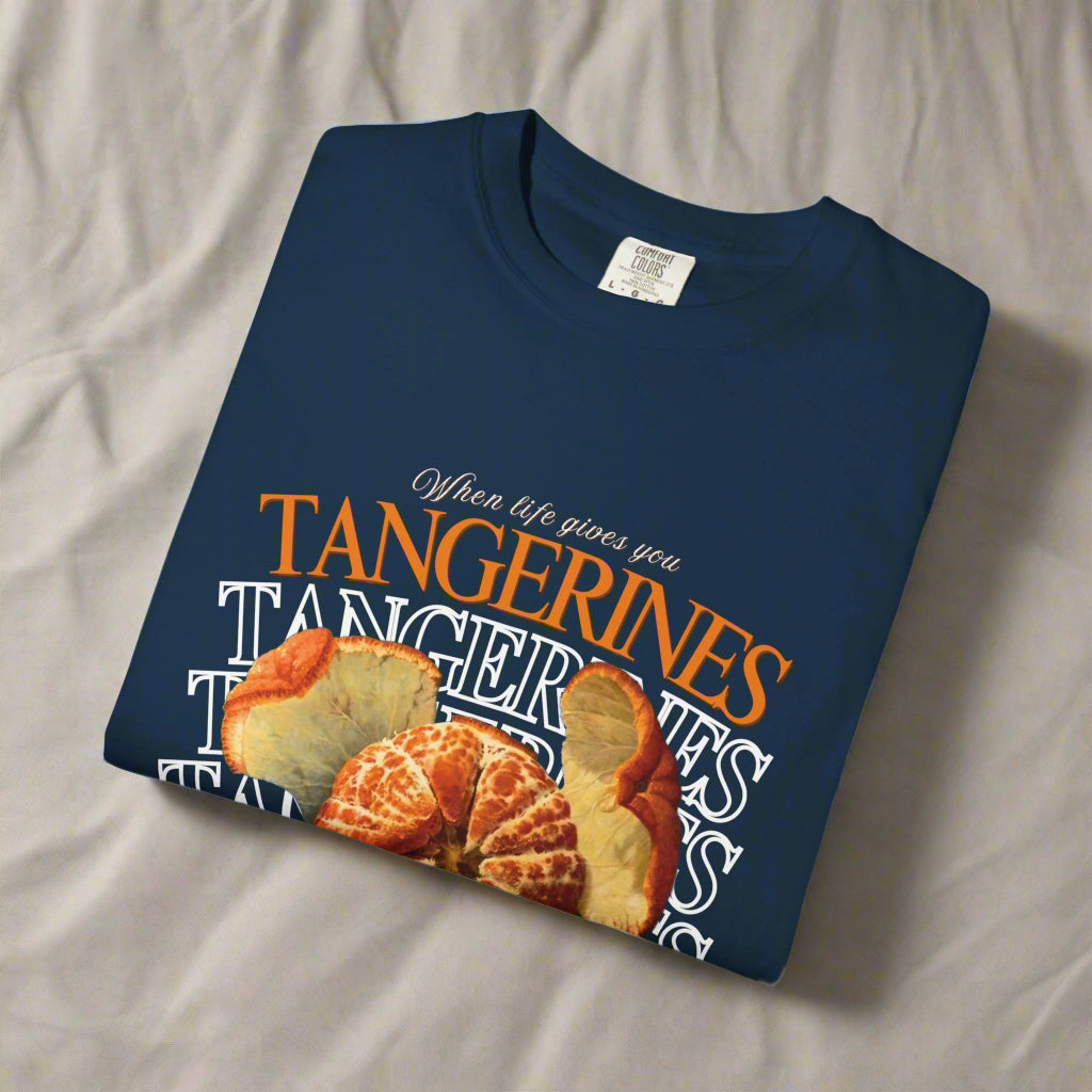 Folded navy blue t-shirt with tangerine graphic and text on a white background