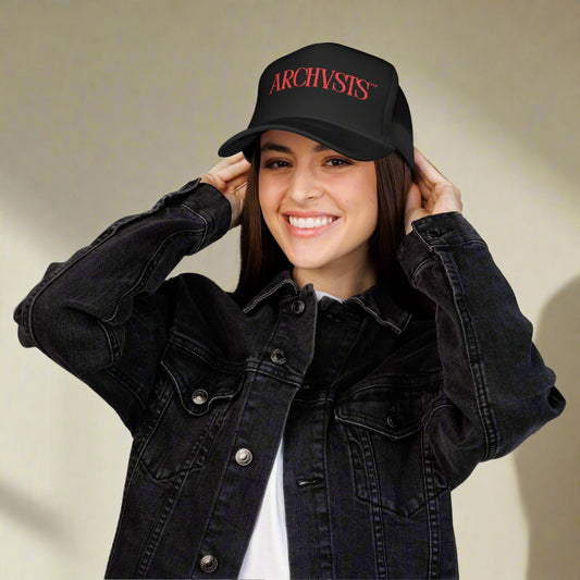 Person wearing a black cap with 'ARCHIVISTS' text and a black denim jacket on a white background